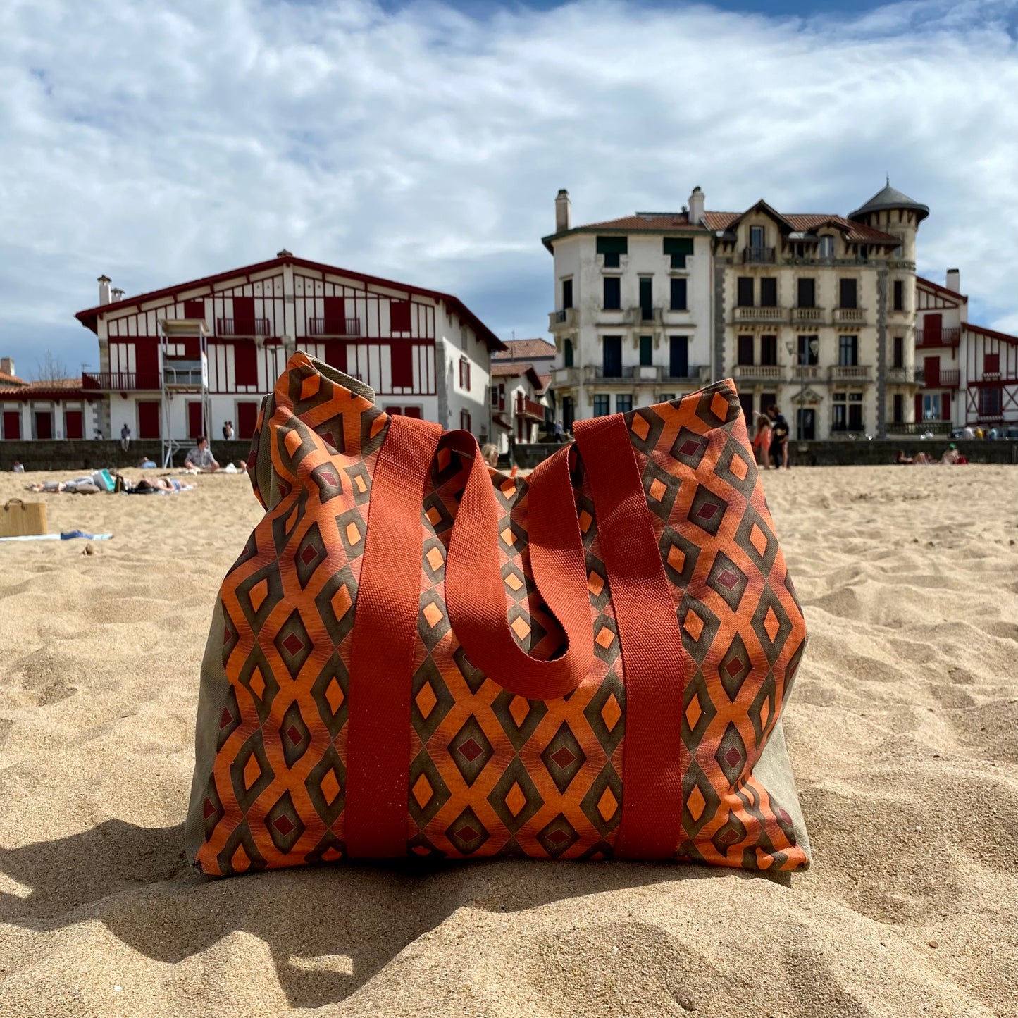 [html] <img src= »grand-cabas-frehel-vue-sur-motif-frehel-et-sangle-couleur-brique-pose-sur-le-sable-plage-cote-basque» /> [/html]